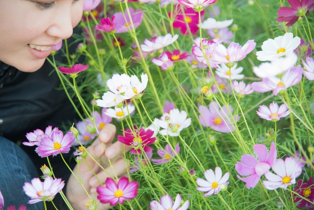 Foto frau und kosmosblumen im blumengarten