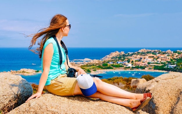 Frau und Landschaft mit felsiger Küste von Capo Testa in Santa Teresa Gallura am Mittelmeer auf der Insel Sardinien im Sommer Italien. Mädchen und Landschaft der Provinz Cagliari. Gemischte Medien.