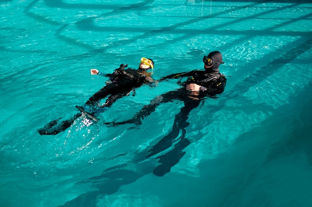 Frau und männlicher Divemaster, Unterricht in der Tauchschule