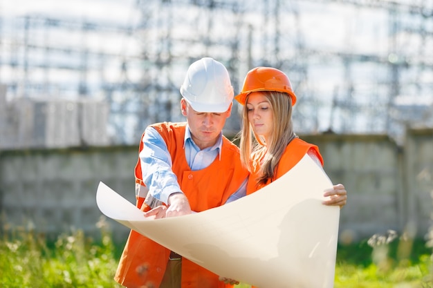 Frau und Mann arbeiten als Architekten auf einer Baustelle