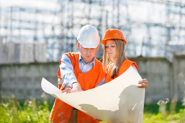 Frau und Mann arbeiten als Architekten auf einer Baustelle