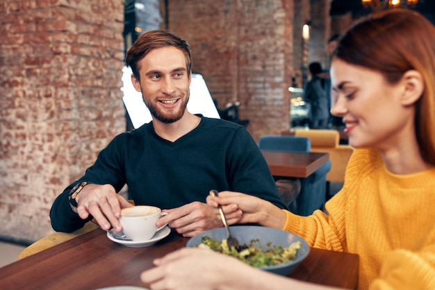 Frau und Mann essen in einem Restaurant, Salat, Essen, eine Tasse Kaffee, Foto in hoher Qualität