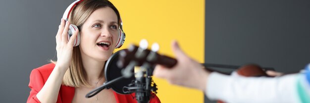 Frau und Mann mit Kopfhörern, die Gitarre singen und spielen, arbeiten als Radiomoderator-Konzept