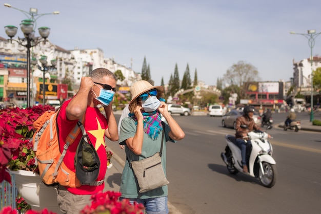 Frau und Mann tragen Hygienemaske im Freien in Da Lat Stadtzentrum Vietnam. Medizinischer Maskenschutz gegen das Risiko des chinesischen Grippevirus in Asien