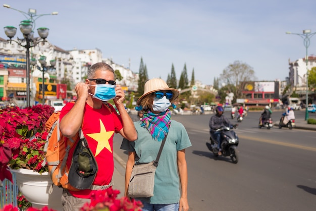 Frau und Mann tragen Hygienemaske im Freien in Da Lat Stadtzentrum Vietnam. Schutz der medizinischen Maske gegen das Risiko des neuen Corona-Virus covid-19 in Asien