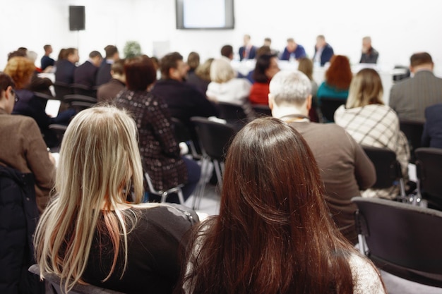 Frau und Menschen, die auf dem horizontalen Bild der Konferenz zuhören