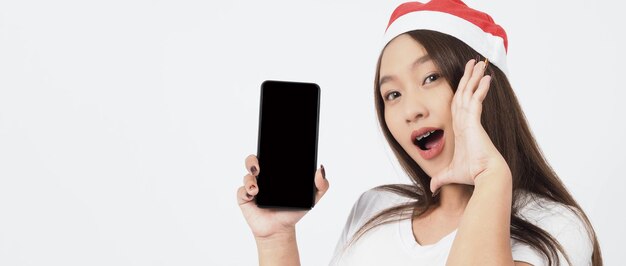 Frau und Smartphone. Asiatische Frau mit Smartphone in der Hand, die wie Selfie oder Videoanruf für Online-Feiern in der Weihnachts- und Neujahrsfestsaison posiert. Teenager Zahnspange glücklich und Smartphone.