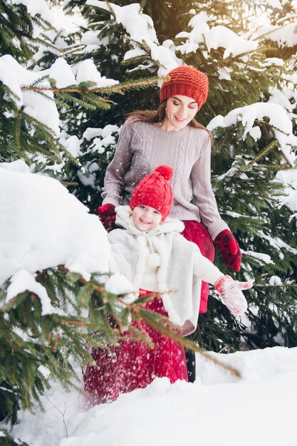 Frau und Tochter haben Spaß im Winterwald
