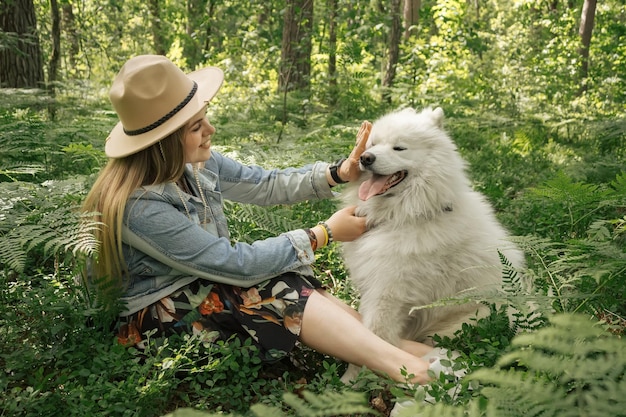 Frau verbringt Zeit mit ihrem flauschigen Hund Samoyed