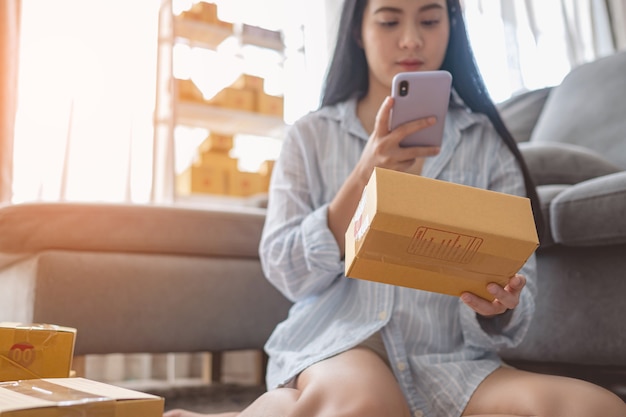 Frau verpackt und verkauft Produkte online. Kleinunternehmen. Arbeiten Sie von zu Hause aus. KMU, die Arbeit zu Hause verkaufen. Gruppe.