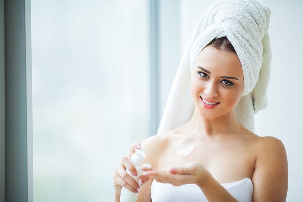 Frau verwenden Hautpflegeprodukte zu Hause im hellen Badezimmer