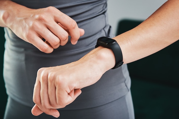 Frau verwendet Fitness-Tracker und macht Sport zu Hause