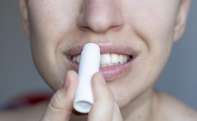 Frau verwendet natürliche Inhaltsstoffe Lippenbalsam große Lippen schönes Lächeln weiße Zähne keine Augen sichtbar