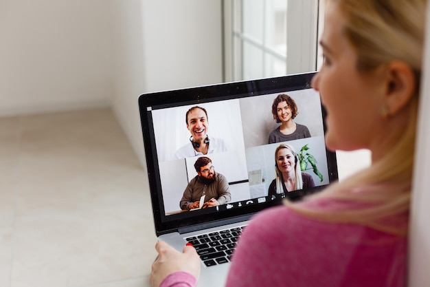 Frau Videokonferenzen mit Tutor auf Laptop zu Hause. Konzept für den Fernunterricht.