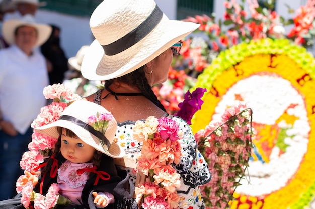 Foto frau von hinten mit hut und typischer tracht der kolumbianischen kultur beim blumenfest