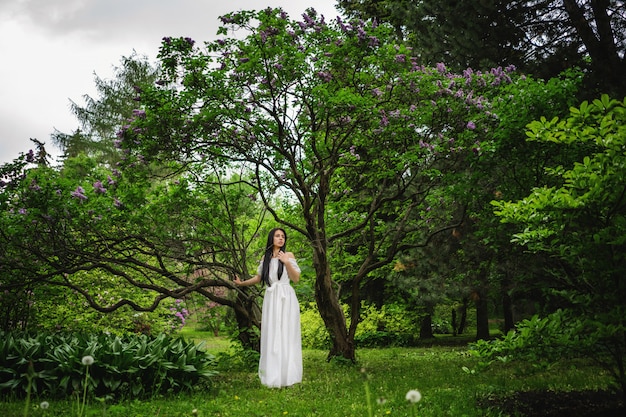 Frau vor dem großen Baum im Park.