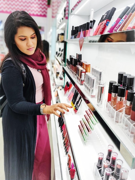 Foto frau wählt make-up-produkte im laden aus