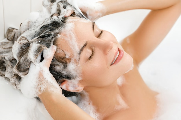 Frau wäscht ihre Haare mit Shampoo