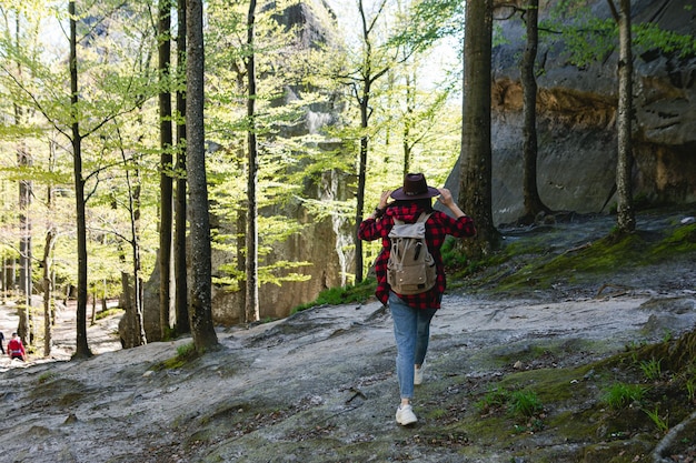 Frau Wanderer mit Rucksack zu Fuß durch den Waldweg