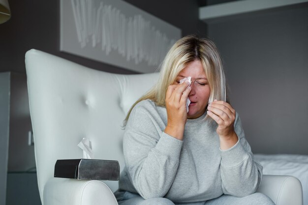 Frau weint im Stuhl im Büro eines Therapeuten bei einer Fettverbrennungstherapie gegen Übergewicht