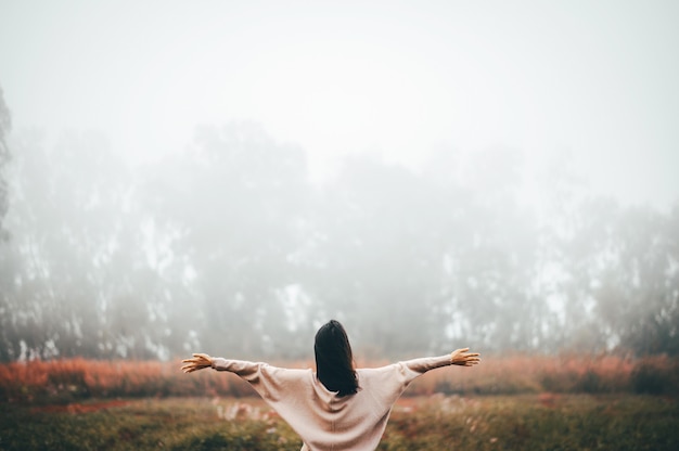 Frau, welche die Freiheit in moring Nebel sich entspannt und genießt