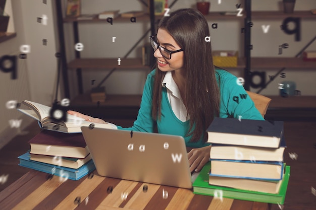 Frau wird ein Buch geöffnet Sie arbeitet mit vielen Büchern und einem Laptop am Tisch