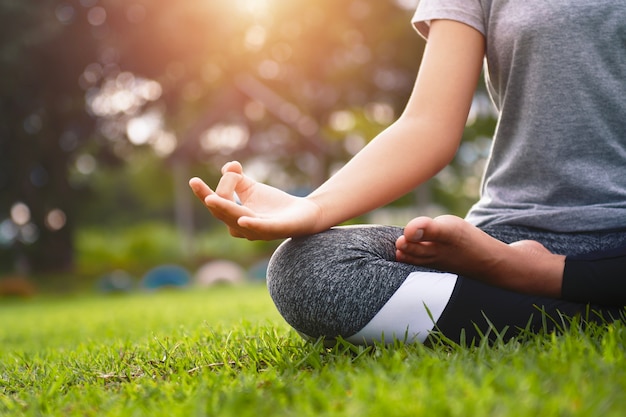 Frau Yoga und meditieren in der Lotus-Position im Park am Morgen