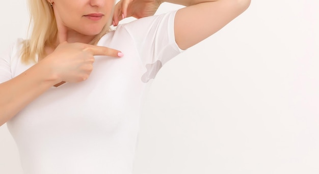 Foto frau zeigt einen fleck auf ihrem weißen t-shirt