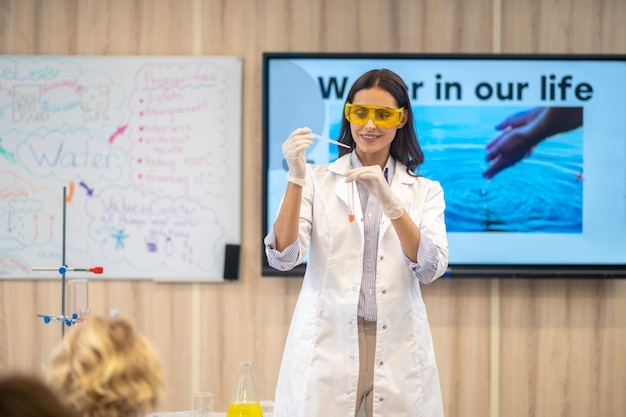 Frau zeigt Kindern im Unterricht Chemieexperimente