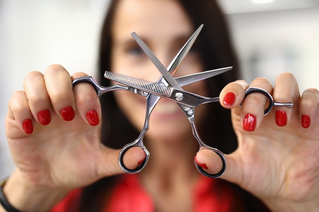 Foto frau zeigt klassische stahlfriseur-werkzeugnahaufnahme