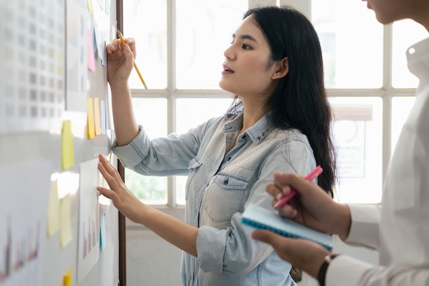 Frau zeigt Plan im Projektmanagement.