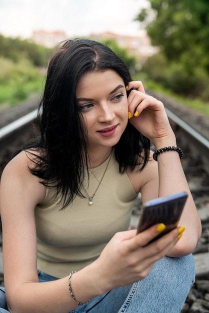 Frau zu Fuß auf den Eisenbahnschienen Sommerlebensstil