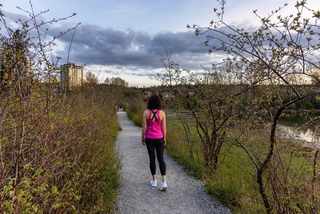 Frau zu Fuß auf einem Pfad mit grünen Bäumen in Shoreline Trail