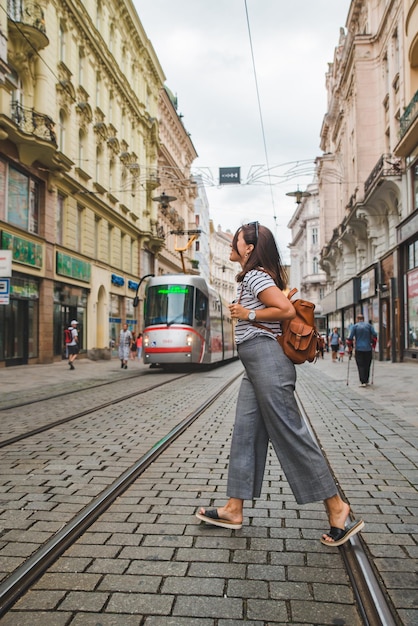 Frau zu Fuß durch die Brünner Altstadt Straße moderne öffentliche Straßenbahn im Hintergrund