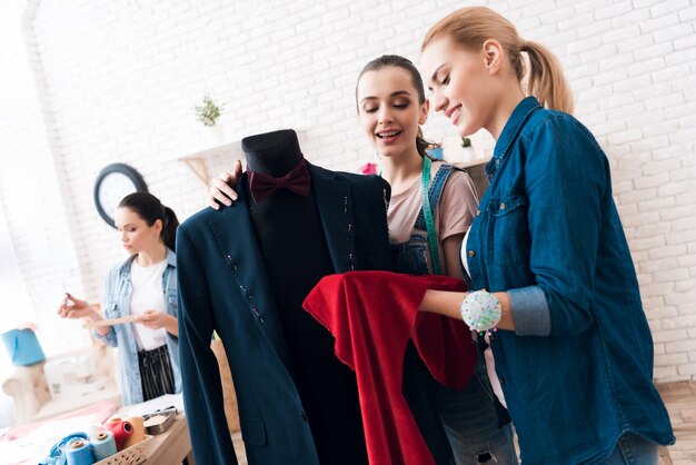 Frauen arbeiten mit Anzug und Farbe zusammen.