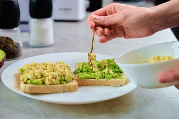 Frauen bereiten Toasts mit gesunder Avocado-Ernährung zu