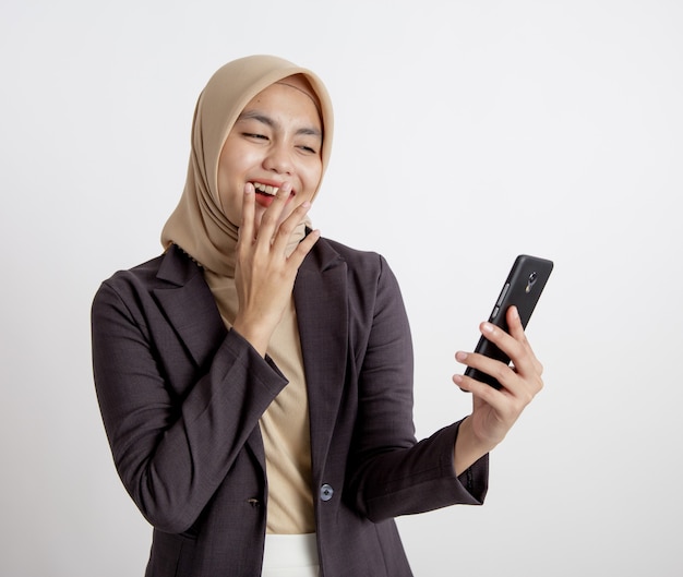 Frauen, die Anzüge hijab Lachen tragen, betrachten das Telefon, formelles Arbeitskonzept lokalisierten weißen Hintergrund