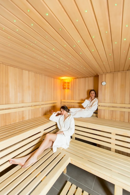 Frauen, die auf der Bank in der Sauna sich entspannen