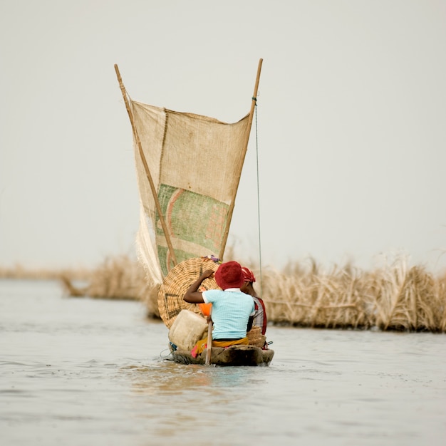 Frauen, die auf der Lagune des Pfahldorfes Ganvie in Benin Boot fahren.