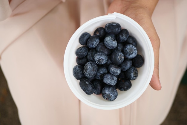 Frauen, die eine Schüssel blaue Beere halten