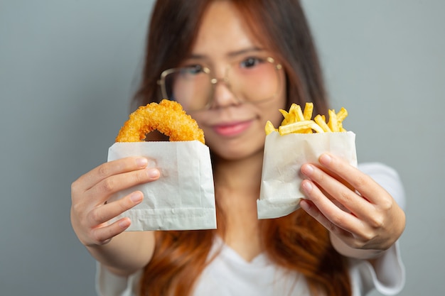 Frauen, die Garnelendonuts auf grauer Oberfläche halten