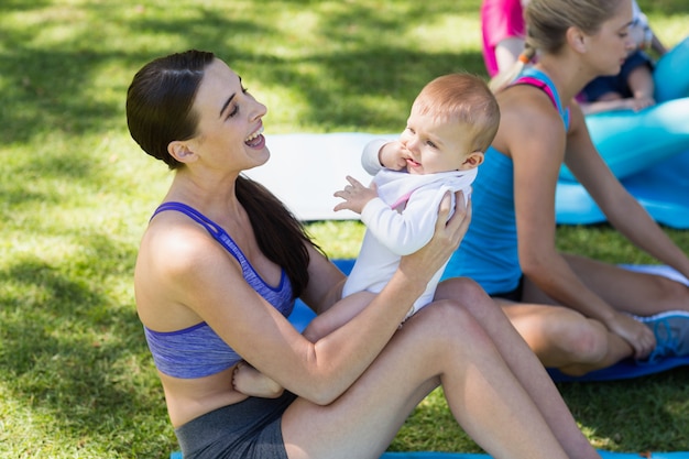 Foto frauen, die ihr baby beim trainieren halten