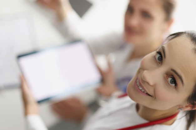 Frauen, die im Krankenhaus arbeiten, verbringen eine Pause mit einem Tablet-Gerät