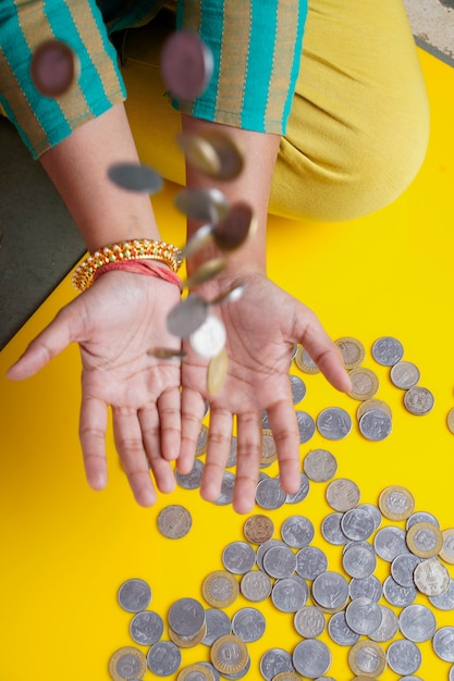 Frauen, die indische Rupien-Münze in der Hand hüpfen