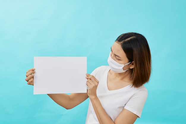 Frauen, die Masken tragen, halten ein weißes Blatt