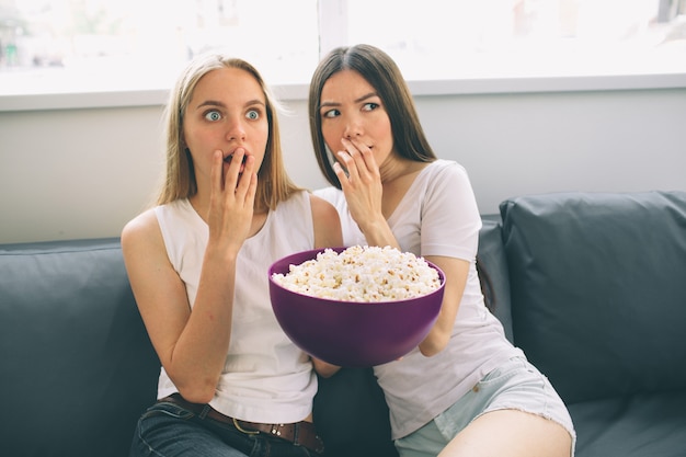 Frauen, die Popcorn essen und fernsehen