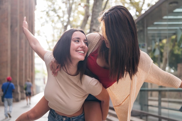 Frauen, die sich huckepack amüsieren