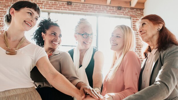 Frauen, die sich in der Mitte die Hände reichen