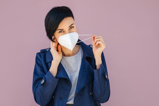 Frauen, die während des Ausbruchs von Covid 19 auf der Straße eine medizinische Schutzmaske aufsetzen. Schutz bei der Prävention des Ausbruchs des Grippevirus, Epidemie. Ein Konzept der Gefahr des Coronavirus.