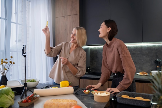 Frauen, die zusammen mittlerer Schuss kochen